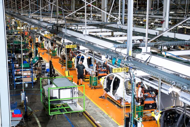 General Motors employees work on a production line at Orion Assembly in Orion Township, Mich., on July 21. GM plans to expand its existing assembly plant in Orion Township, outside Detroit, to convert the compact EV plant to make electric pickup trucks and assemble battery packs. CREDIT: Photo for The Washington Post by Nic Antaya