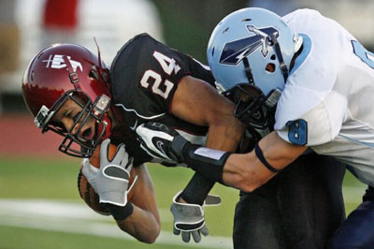 St. Joseph's Prep's Greg Castillo is brought down by North Penn's Ronnie Akins, on ground (not pictured), and Anthony Taggart in last year's season opener. The Knights won, 17-7. (Ron Cortes / Inquirer)