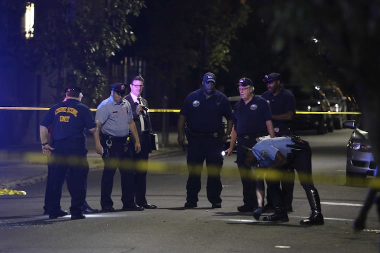 Investigators search for ballistic evidence on Sansom Street after a gunman shot two police officers and four civilians.