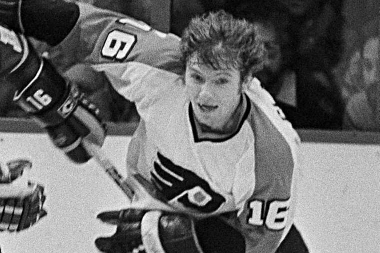 Los Angeles Kings Marcel Dionne (16), left, uses his stick to try and keep Flyers Bobby Clarke from picking up the loose puck in the first period of NHL game in Philadelphia, on Thursday, night, Dec. 6, 1979. (Kennedy/AP)