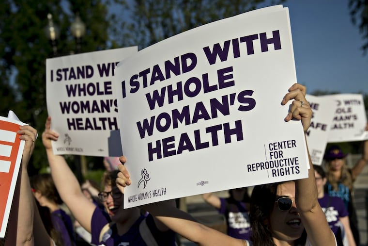 FILE – Pro-choice advocates hold signs outside the U.S. Supreme Court before rulings in Washington on June 27, 2016.
