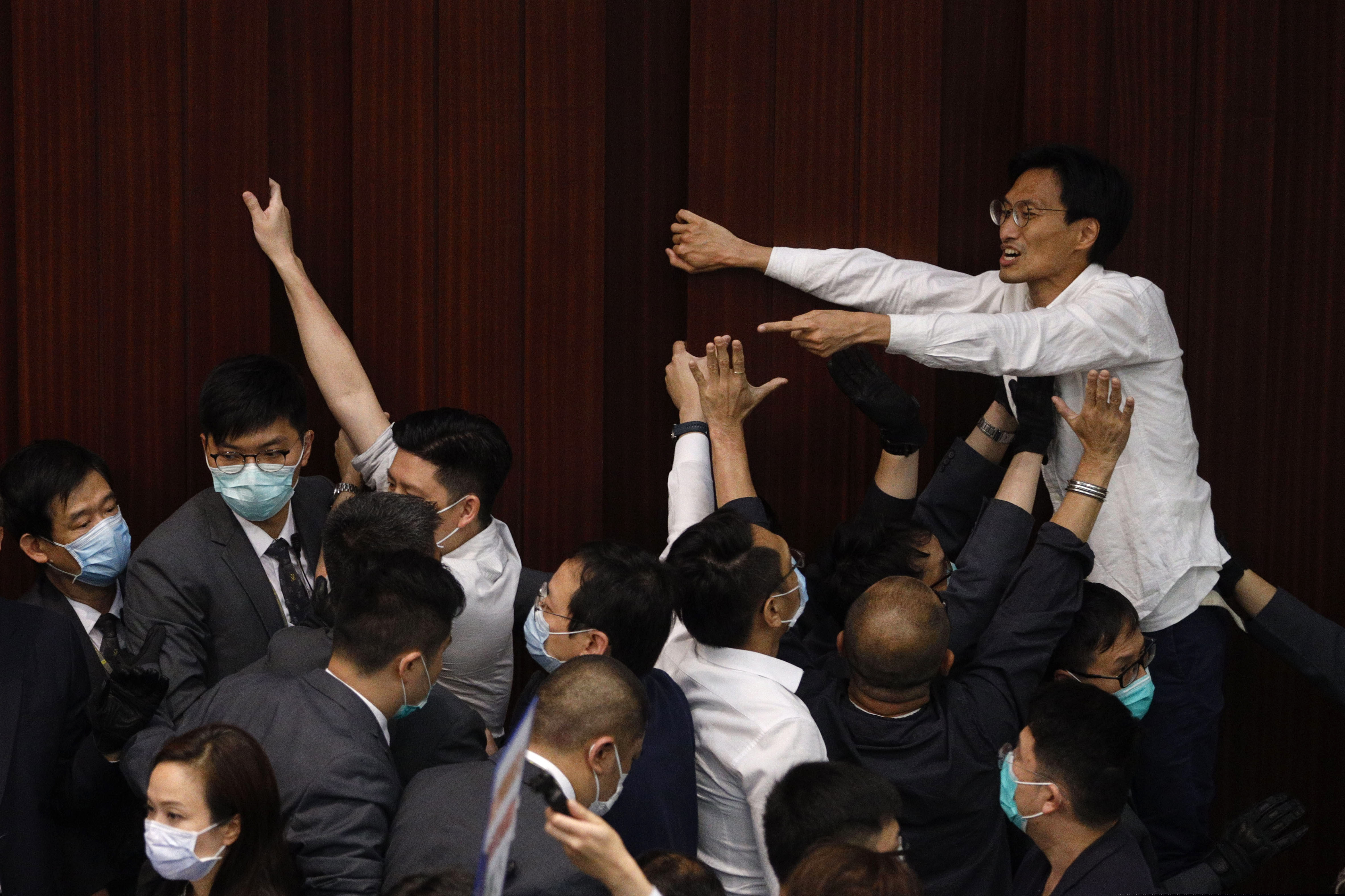 Pan-democratic legislator Eddie Chu Hoi Dick scuffles with security guards during a Legislative Council's House Committee meeting, in Hong Kong on Friday.
