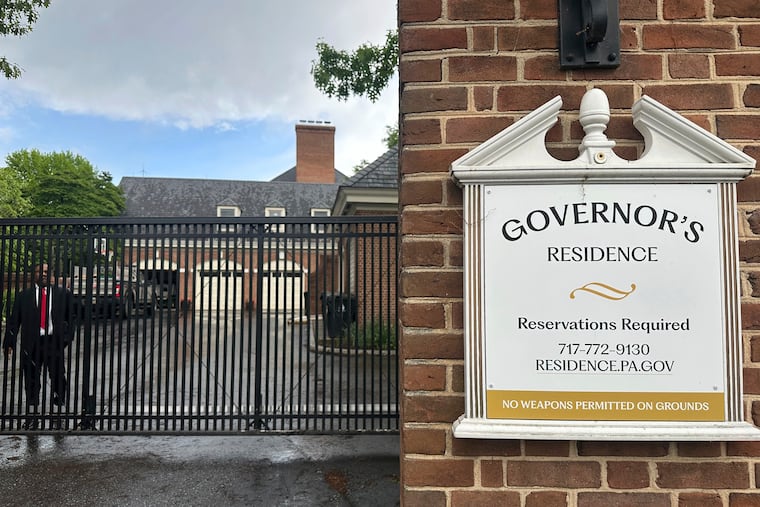 A member of Pennsylvania Gov. Josh Shapiro's state police protective detail stands on duty behind an entrance at the governor's official residence in Harrisburg, Pa., Tuesday, May 6, 2025. (AP Photo/Mark Scolforo)