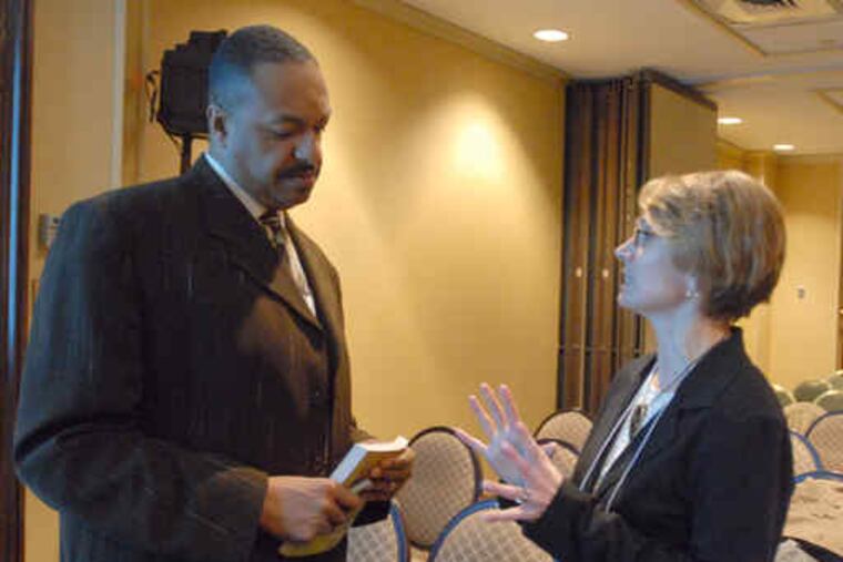 On a break in the "Children and War" conference, hosted by Rutgers-Camden, doctoral candidate Thomas Holmes confers with childhood-studies department chair Lynne Vallone.