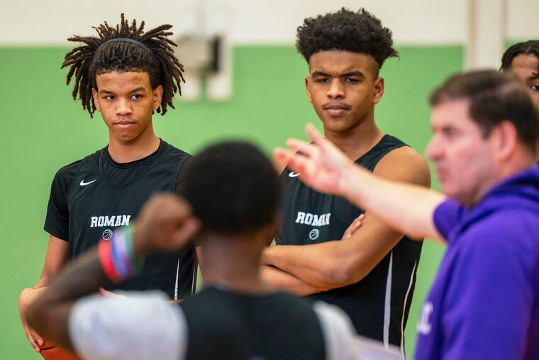 Roman Catholic's Sammy Jackson (left) and Shareef Jackson listen to coach Chris McNesby during practice on Wednesday.
