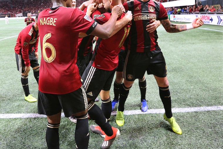 Atlanta United players mob Hector Villalba after his goal in their 3-0 victory over the New York Red Bulls.