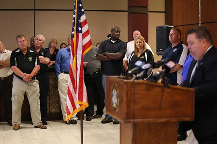 A crowd listens as John J. McNesby, right, president of Philadelphia Lodge 5 Fraternal Order of Police, speaks during a news conference at the lodge in Northeast Philadelphia on July 16, 2014. McNesby questioned the reporting in the Philadelphia Daily News series "Tainted Justice."