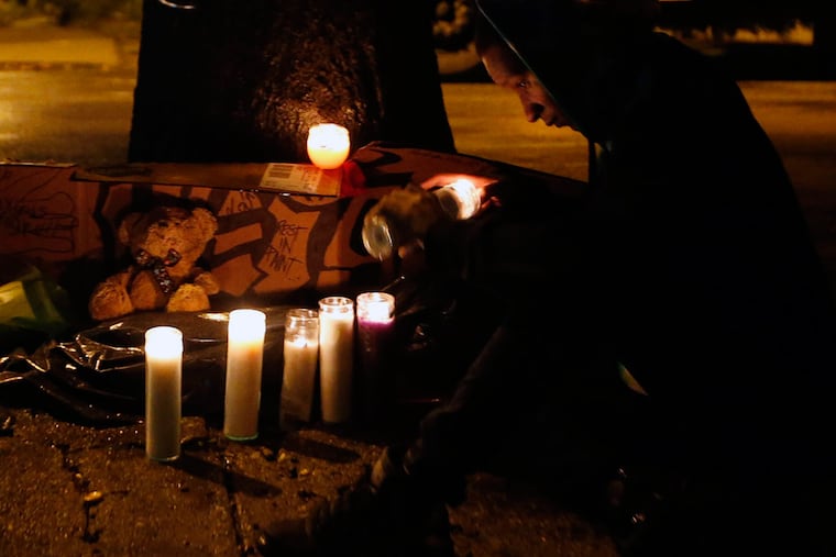 Tysheen Choice, 28, lights a candle during a vigil for Kiesha Jenkins at 13th and Wingohocking Streets in North Philadelphia on Friday, Oct. 9, 2015. (YONG KIM/Staff Photographer)