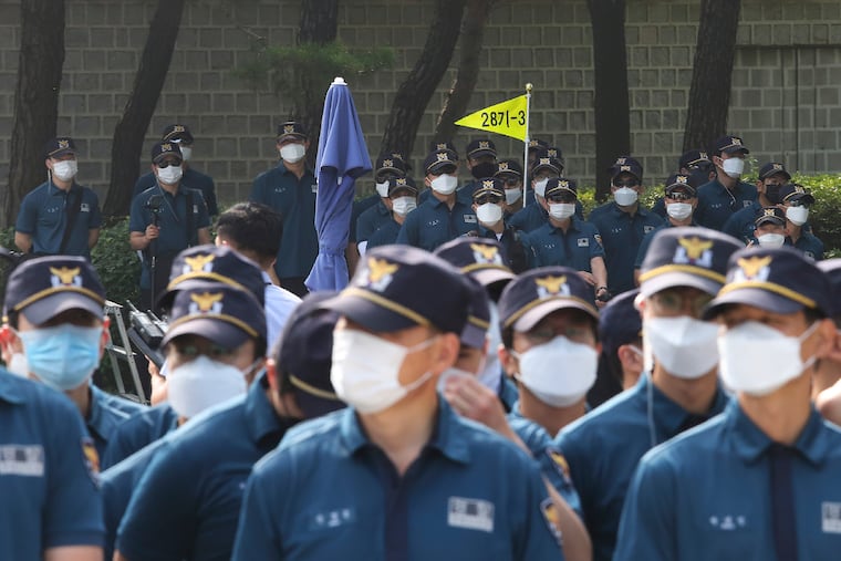 Countries like South Korea, with greater adherence to trust public health measures like mask-wearing, have seen their coronavirus cases come down. Here, police officers stand guard near the presidential Blue House in Seoul on July 9, 2020. (AP Photo/Ahn Young-joon)