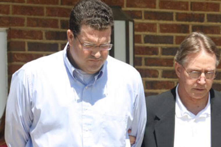 Michael W. McDonnell is led from his arraignment in Doylestown on Friday by an unidentified law enforcement official. (Photo by Larry King)