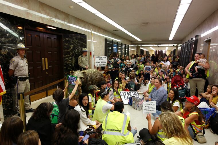 Opponents of a measure that would give public health officials oversight of doctors that may be giving fraudulent medical exemptions from vaccinations during gathered in front of the governor's office after it was approved by the Assembly Health Committee at the Capitol in Sacramento, Calif., June 20, 2019. Politicizing vaccines runs a public health risk, writes Dominik Stecula.