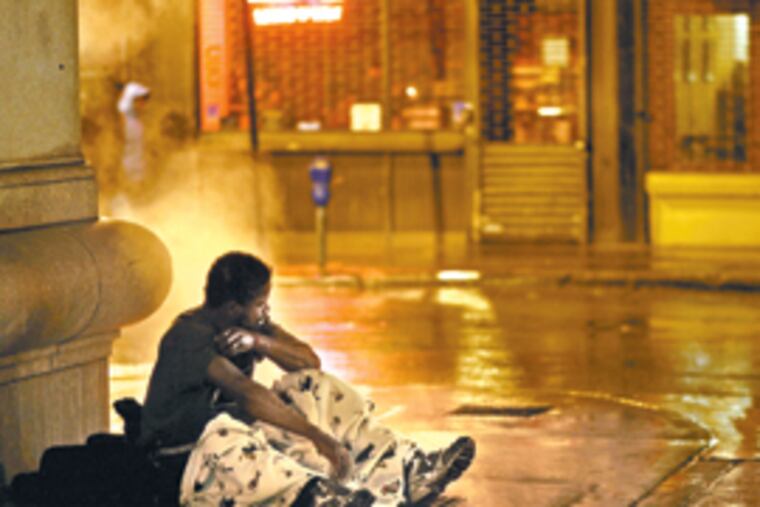On Moravian Street, a homeless man tries to keep warm on a vent near 15th Street.