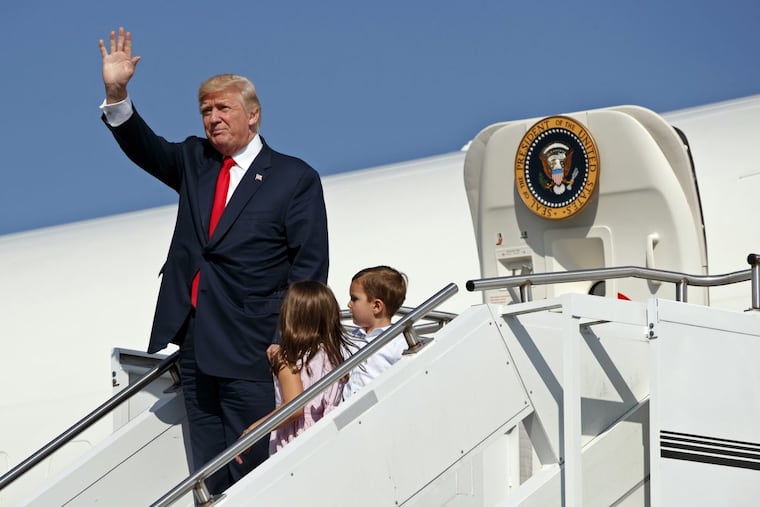 President Trump waves as he walks down the steps of Air Force One with his grandchildren, Arabella Kushner, center, and Joseph Kushner, right, after arriving at Morristown Municipal Airport to begin his summer vacation at his Bedminster golf club in August 2017.