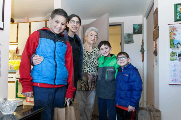 On Sunday, Talia, Max and Joel Kepniss, along with more than 300 Project H.O.P.E volunteers, delivered food boxes to resident of Saligman House, such as Feyga Karp (center), for Passover, which starts on Friday night.