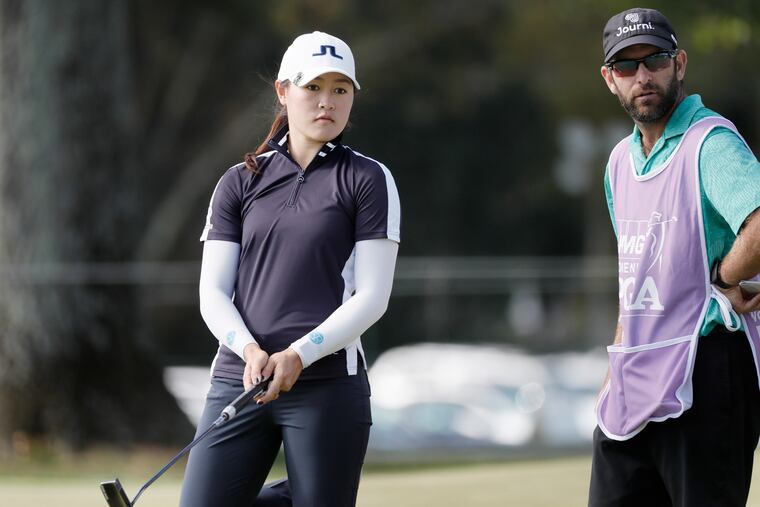 Kelly Tan and her caddy watch as she sinks her putt on 18 in Thursday's first round of the 2020 KPMG Women’s PGA Championship at Aronimink Golf Club in Newtown Square.