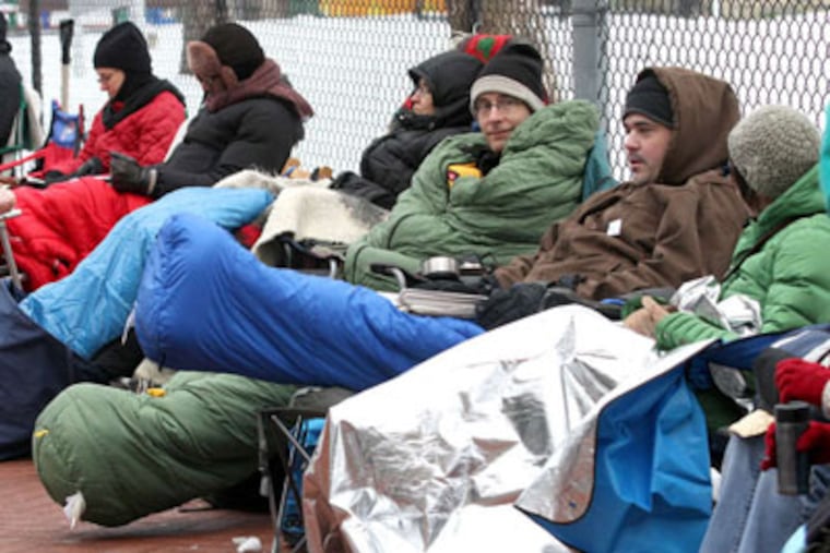Parents line the street of the Penn Alexander School, in the cold, with the hopes of securing a spot for their child in next year's kindergarten class. (Charles Fox / Staff)