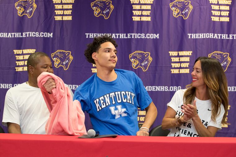Flanked by his parents, Stephen Ware and Monique Ware, Camden High basketball star Lance Ware announced he will attend Kentucky by pulling off his sweatshirt to reveal his choice on a T-shirt.