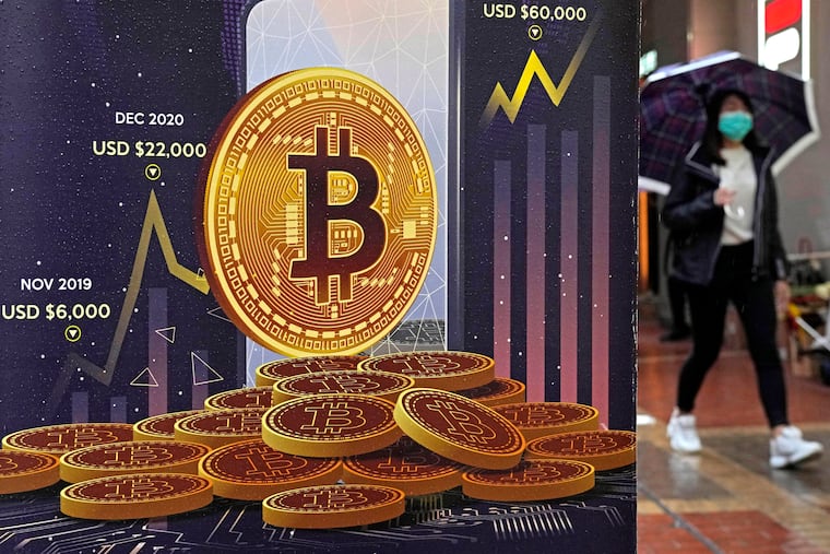 An advertisement for Bitcoin cryptocurrency is displayed on a street in Hong Kong on Feb. 17, 2022. The recent crypto-asset meltdowns that wiped out more than $2 trillion in value highlight the need for tougher financial regulations.
