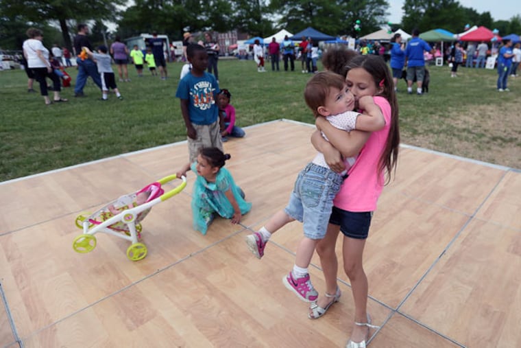 Ariana Severs, 9, gives her sister, Kali Rivera, 1, a kiss on the dance floor during Burlington Day on May 16, 2015. ( DAVID MAIALETTI / Staff Photographer )