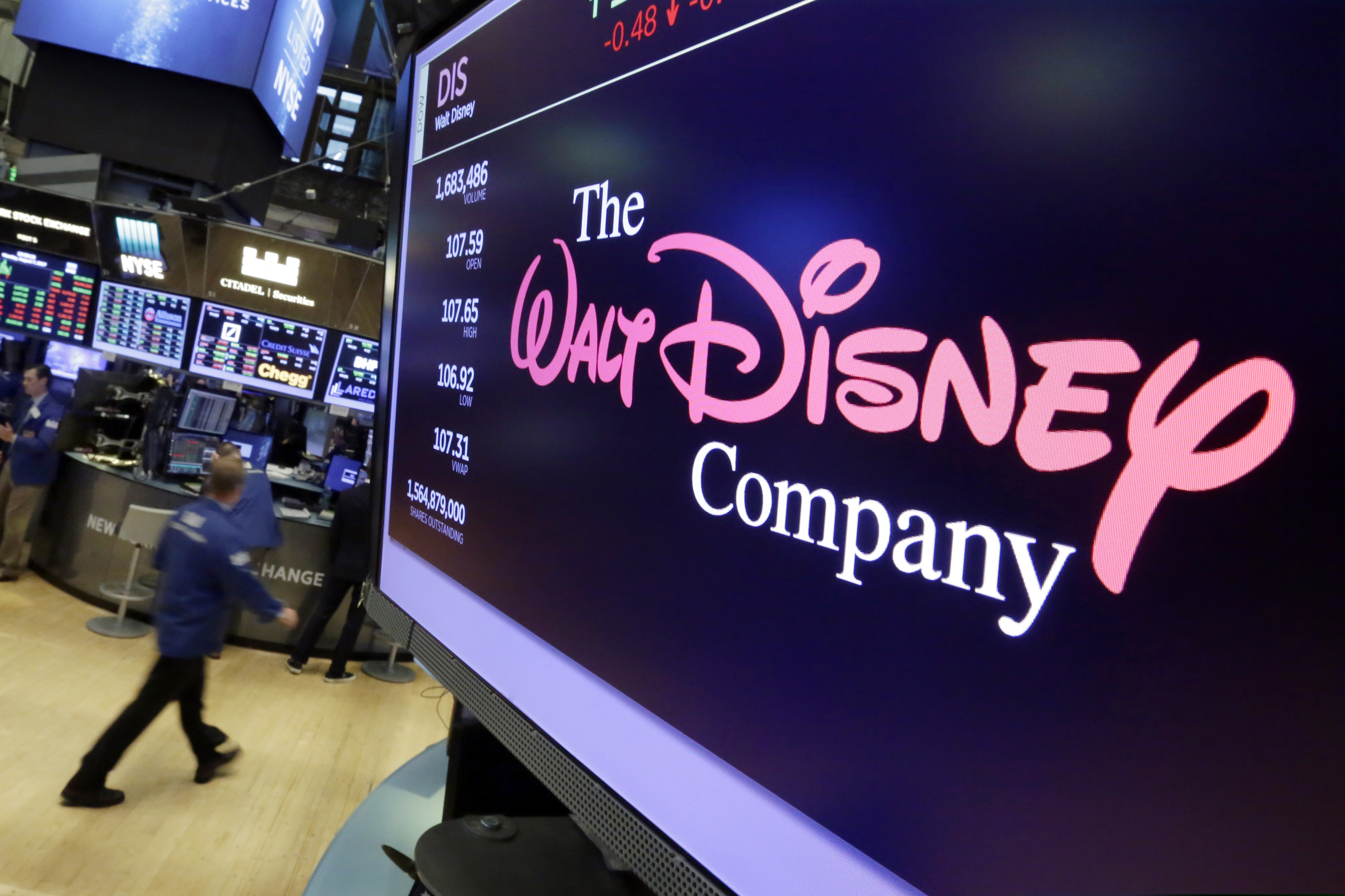FILE - In this Aug. 8, 2017, file photo, The Walt Disney Co. logo appears on a screen above the floor of the New York Stock Exchange. On Thursday, April 11, Disney unveiled details of its long-awaited streaming service Disney Plus.