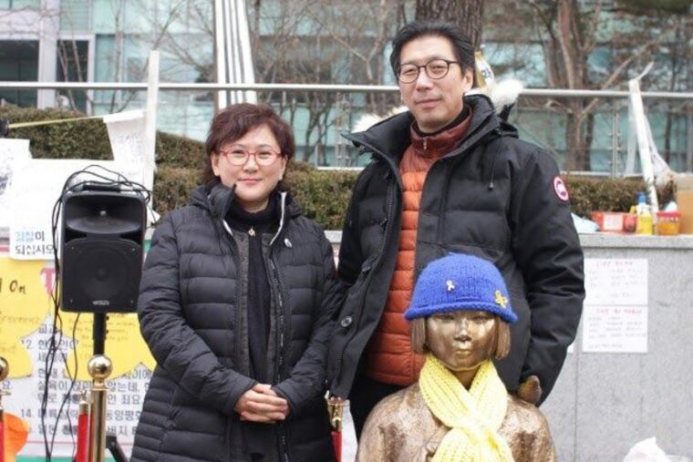 Sculptors Kim Seo Kyung (left) and Kim Un Sung pose with “Statue of a Girl of Peace” in front of the Japanese Embassy in Seoul, a version of which is being proposed in Queen Village. (Courtesy of the artists)