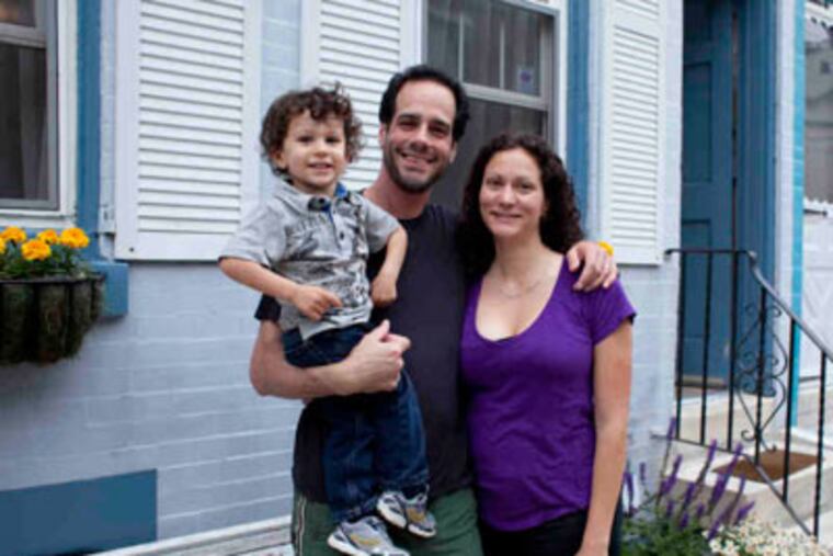 Tara Martello, husband Stephen Ballerini and son, John, 2, at their Fairmount home. Two years ago, someone stole a tree at their home. They replaced it with flowers, which also were stolen. (ED HILLE / Staff Photographer)