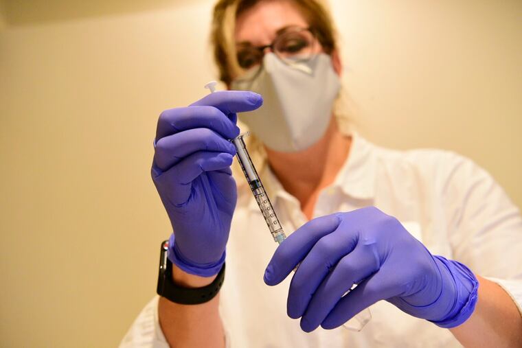 A pharmacist prepares to give the experimental Johnson & Johsnon COVID-19 vaccine.