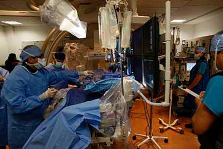 A surgical team gets ready at Thomas Jefferson University Hospital, one of two city hospitals working to reduce its rate of 'diversions' -- when ambulances are advised to steer clear because of a too-full emergency room. (Michael S. Wirtz / Staff / File)