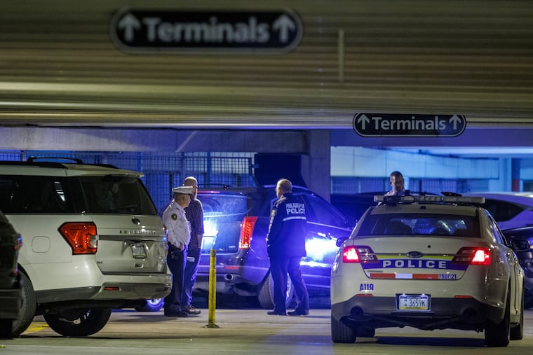 Philadelphia police officers and patrol car inside Terminal D parking lot at Philadelphia International Airport, where two officers were shot in the parking lot, and one died.