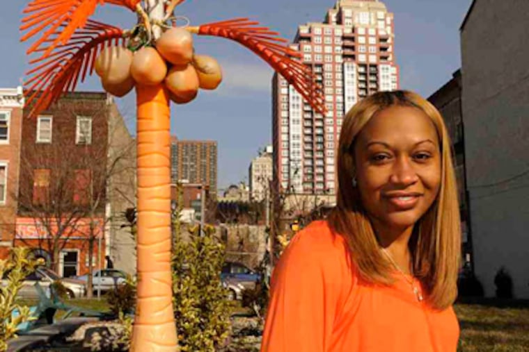 Lisa Wilson outside her Jamaican Jerk Hut on South Street, with the Symphony House condominiums behind her. (Clem Murray / Staff Photographer)