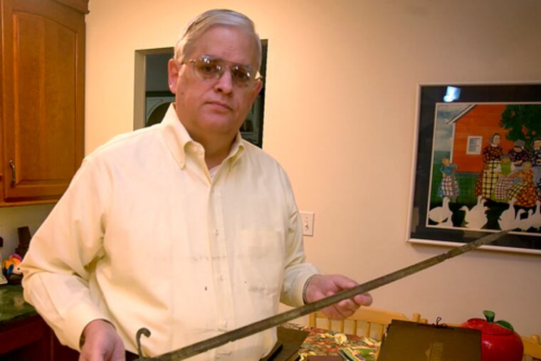 Frank Mood Jr., a family friend in Sykesville, Md., holds the ceremonial sword that Hittorff received as a midshipman.It was corroded from months in the harbor.