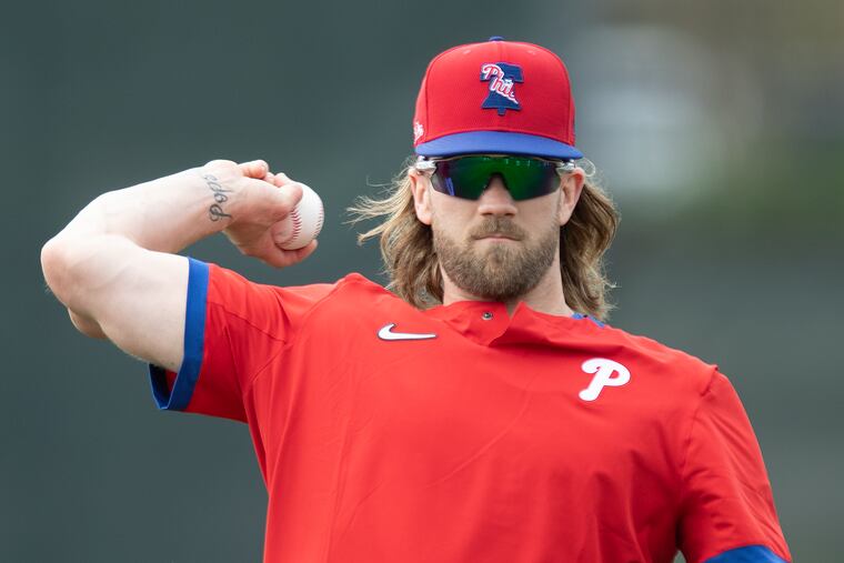 Bryce Harper plays catch Wednesday during the Phillies' spring-training workout in Clearwater, Fla.