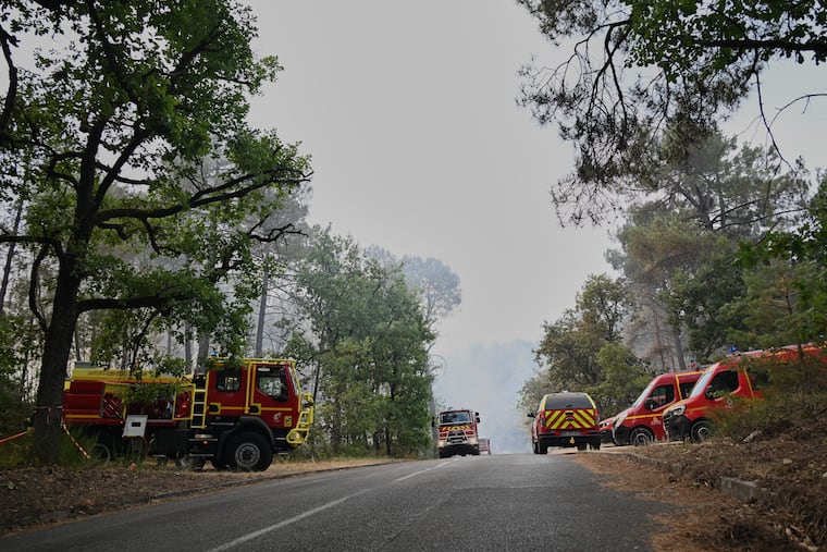 Fire trucks are parked near the scene of a wildfire in the region of the historic Fontainebleau forest, about 37 miles south of Paris, France, Monday, July 13, 2026.