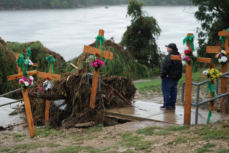Rain falls as Irene Valdez visits a make-shift memorial for flood victims along the Guadalupe River on July 13 in Kerrville, Texas.