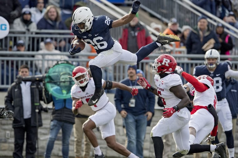 Penn State running back Saquon Barkley leaps over Rutgers defenders on Saturday.