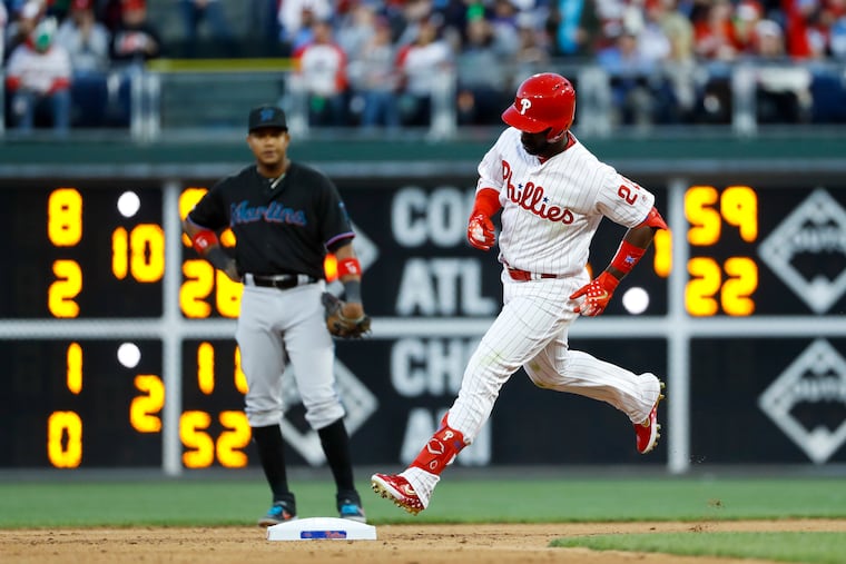 Philadelphia Phillies' Andrew McCutchen, right, rounds the bases past Miami Marlins second baseman Starlin Castro after hitting a home run off starting pitcher Trevor Richards during the fourth inning of a baseball game, Saturday, April 27, 2019, in Philadelphia. (AP Photo/Matt Slocum)