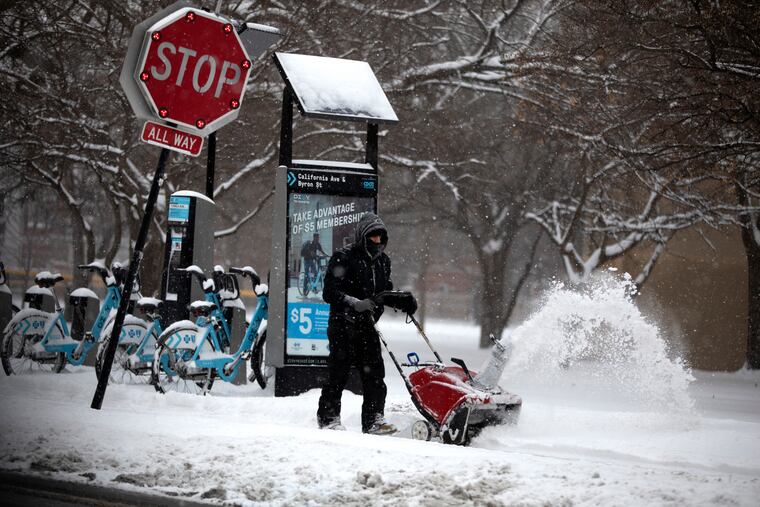 Snow is removed from the sidewalk in front of the McFetridge Sports Center Saturday, Jan. 19, 2019, in Chicago. (Erin Hooley/Chicago Tribune via AP)