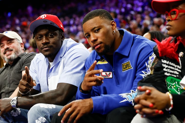 Eagles wide receiver A.J. Brown (left) and running back Saquon Barkley attending the Sixers' Game 6 against the Knicks on May 2.