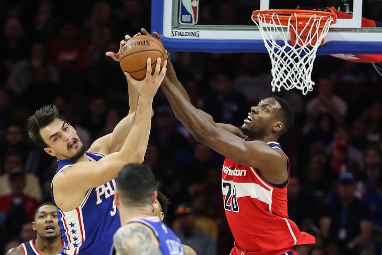 Dario Saric battling for a rebound with the Wizards' Ian Mahinmi in November.