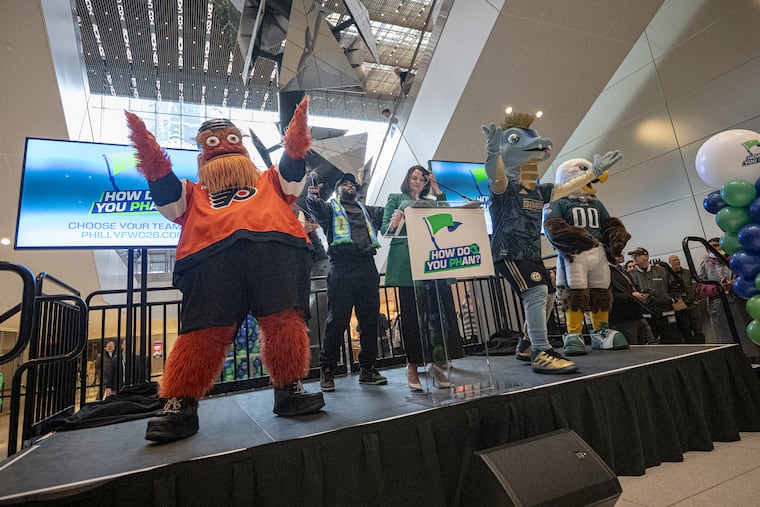Eagles defensive end Brandon Graham alongside Meg Kane, host city executive and CEO of Philadelphia Soccer 2026, are surrounded by Philly sports mascots during Tuesday's event kicking off 100 days until the 2026 FIFA World Cup at the Comcast Center.