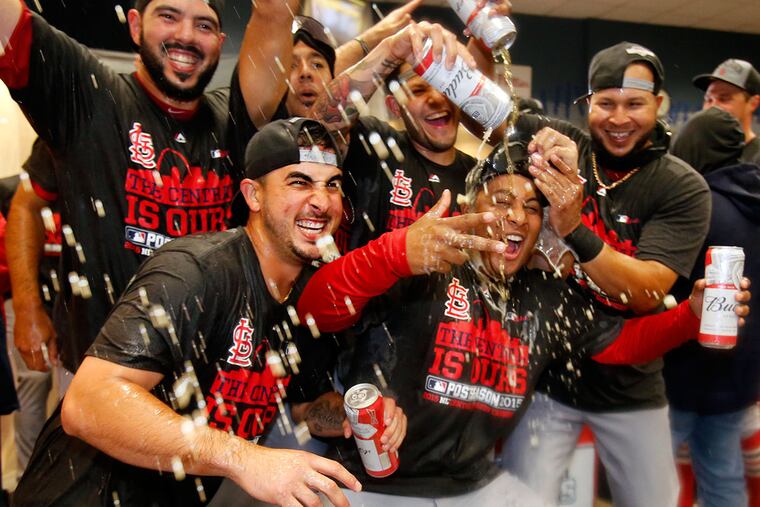 A group of St. Louis Cardinals players pose for their team photographer while celebrating after clinching the Central Division with an 11-1 win over the Pittsburgh Pirates in a baseball game in Pittsburgh, Wednesday, Sept. 30, 2015. (AP Photo/Gene J. Puskar)