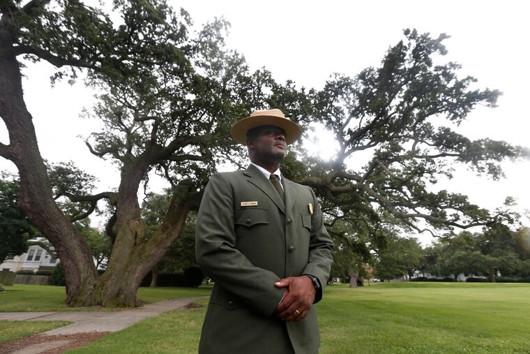 Terry E. Brown, Superintendent of the Fort Monroe National Monument stands in front of what he calls the witness tree, a 500-year-old oak, that was near the the spot of the first landing of Africans in America 400 years ago at Fort Monroe in Hampton, Va.