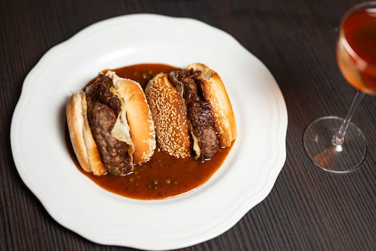 Known Associates' burger is cut and plated in a peppercorn sauce.