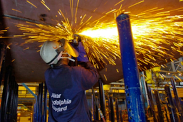 as shipfitter Jamal Abdullah works on a hull. The yard has a four-year apprentice program.