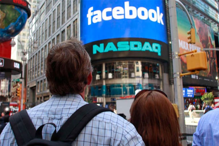 Visitors to Manhattan watch the monitor welcoming Facebook before the start of trading. "It wasn't quite as exciting as it could have been," one analyst said. (Bebeto Matthews / AP)