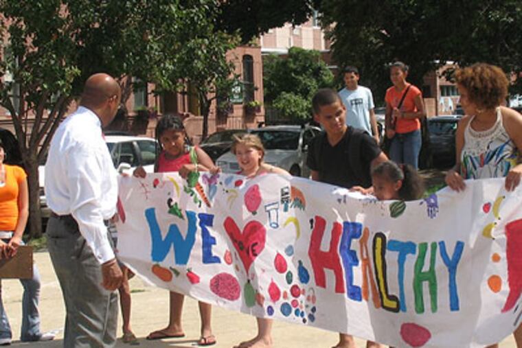 A school class greets Mayor Nutter with a poster saying "We love Healthy" outside the Farmers Market in Norris Square in North Philadelphia. (Photo by Michael Brocker)