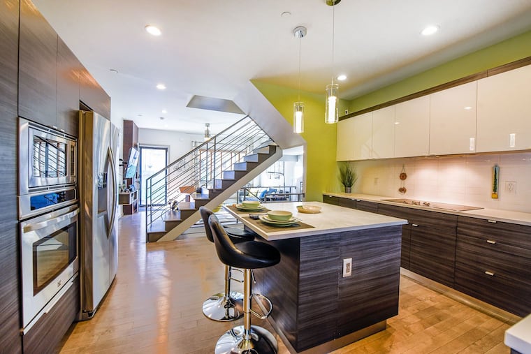 The eat-in kitchen with island seating had quartz countertops and imported backsplash tile with pendant lighting, stainless steel appliances, a Bosch dishwasher, and front-load washer and dryer.