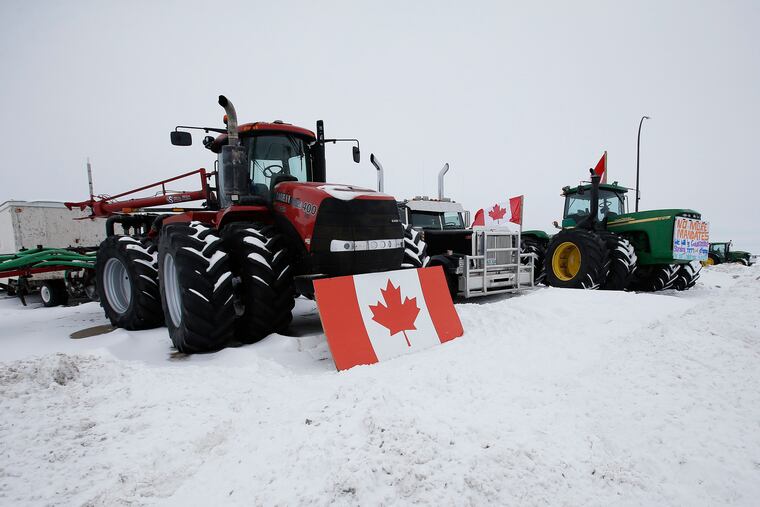 People block highway 75 with heavy trucks and farm equipment and access to the Canada-United States border crossing at Emerson, Manitoba, on Thursday.
