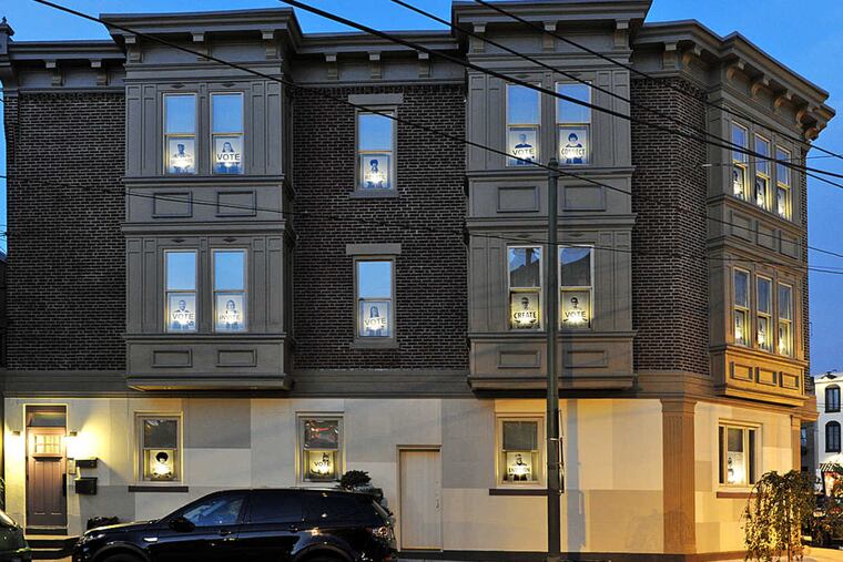 Photo of the house Kate Mellina and Dave Christopher own on East Passyunk Ave and Tasker St., which features uplifting phrases about voting and portraits of locals.