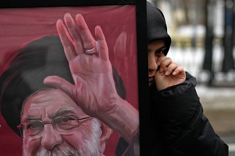 An Iranian woman wipes away a tear as other students studying in Russia gather Monday at a memorial for the late Iranian Supreme Leader Ayatollah Ali Khamenei set up outside Iran's embassy in Moscow.